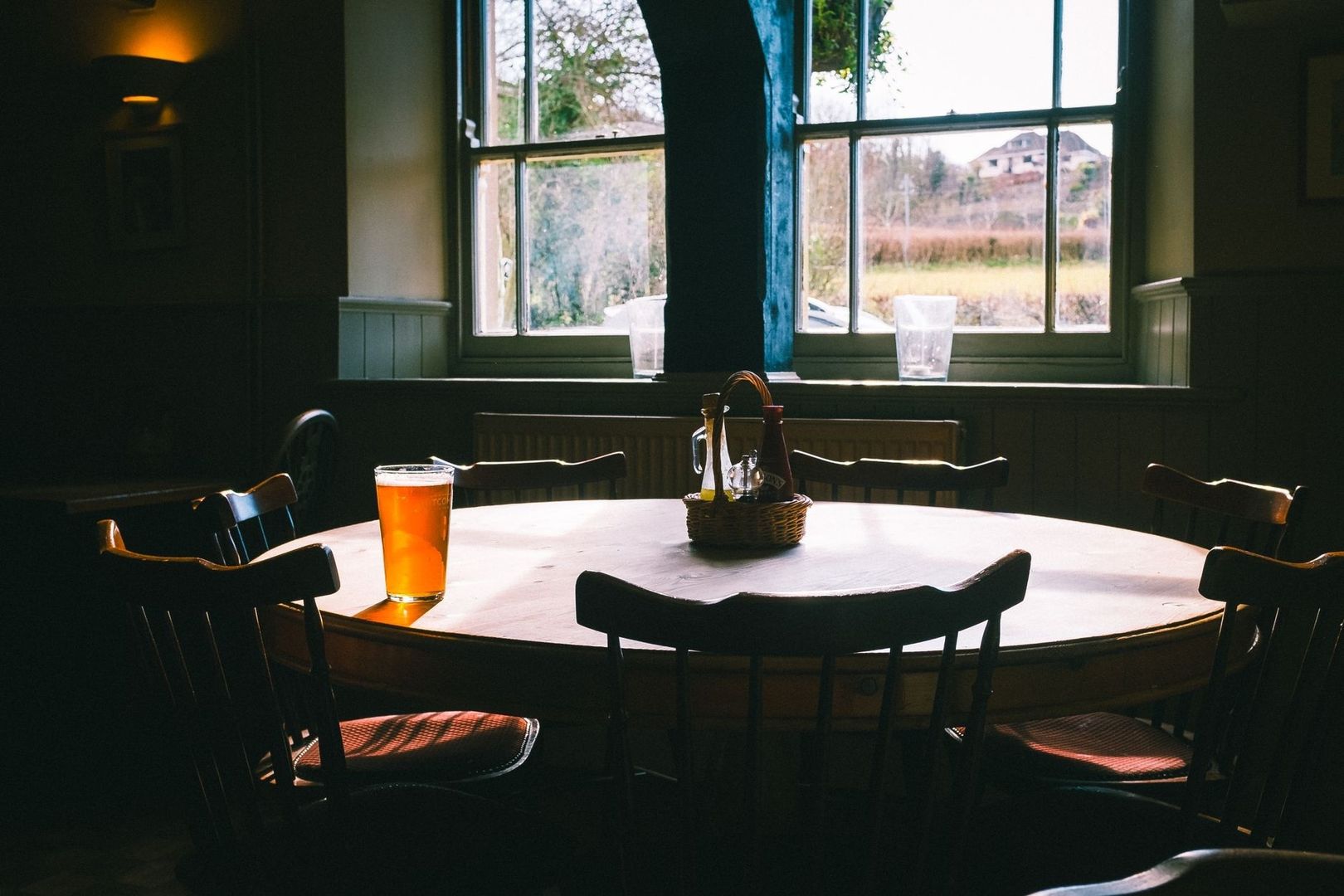 Cozy pub dining room with a pint on a round wooden table