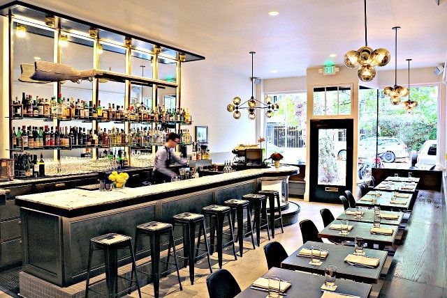 Bright pub with solo-friendly bar stools and neatly set dining tables