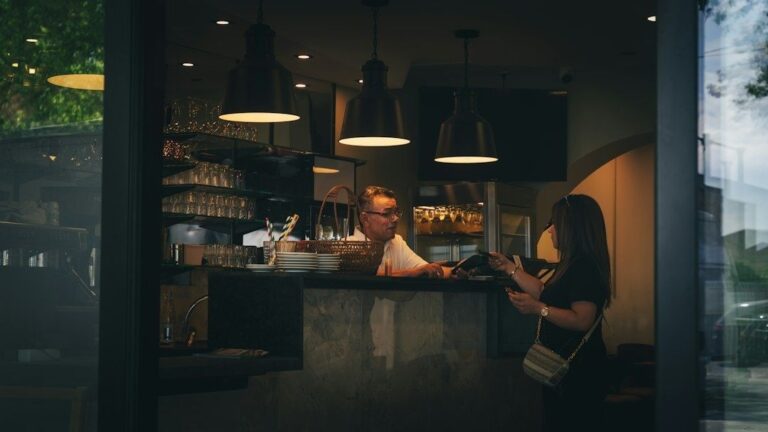 Woman receives attentive service at a warmly lit pub counter