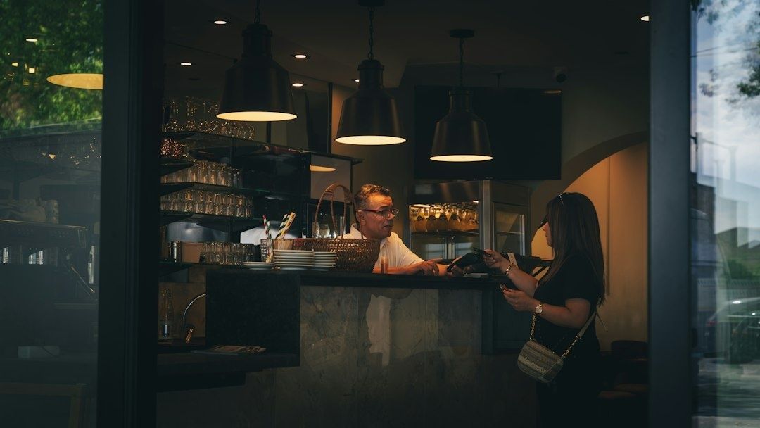 Woman receives attentive service at a warmly lit pub counter